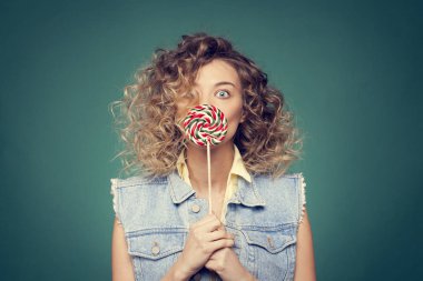 Genç kadın lolipopla poz veriyor.