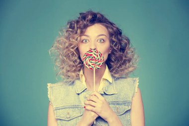 Genç kadın lolipopla poz veriyor.