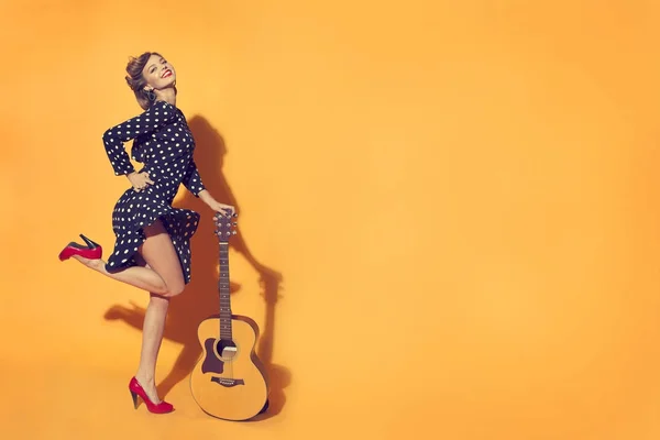 Молода жінка спирається на гітару — стокове фото