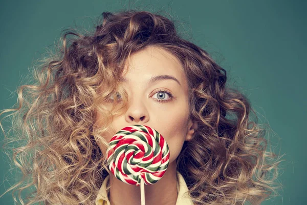 Genç kadın lolipopla poz veriyor.