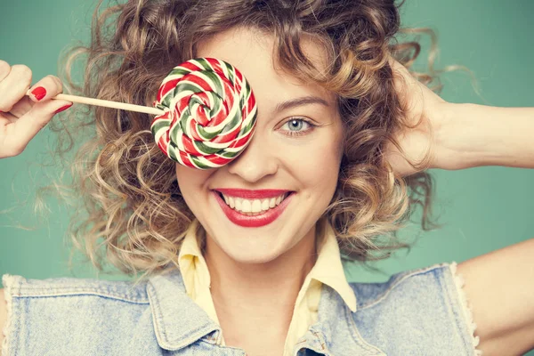 Genç kadın lolipopla poz veriyor.