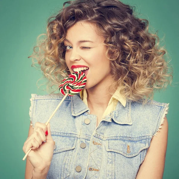 Genç kadın lolipopla poz veriyor.