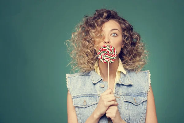 Genç kadın lolipopla poz veriyor.
