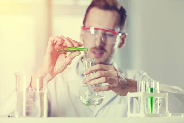 Химик держит флакон и фляжку — стоковое фото