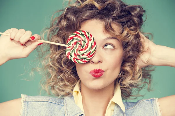 Genç kadın lolipopla poz veriyor.