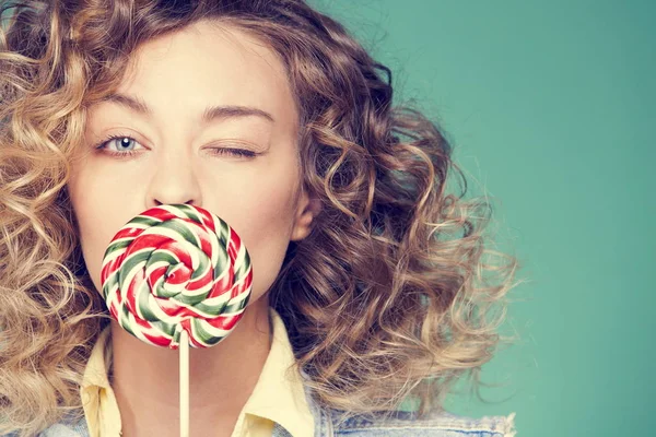 Genç kadın lolipopla poz veriyor.
