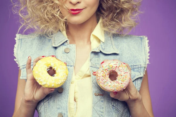 Молода жінка тримає пончики — стокове фото