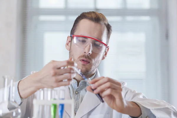 Jovem cientista a encher o frasco — Fotografia de Stock