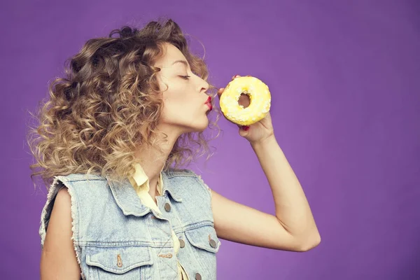 Şık kıvırcık kız mor zemin üzerine çörek öpüşme