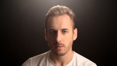 Genç sarışın adam kameraya bakan portresi