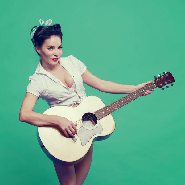 beautiful girl in pin-up style playing guitar