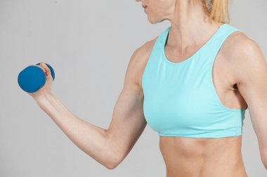 Orta yaşlı spor kadın dumbbell ile çalışma dışarı güçlü elleriyle