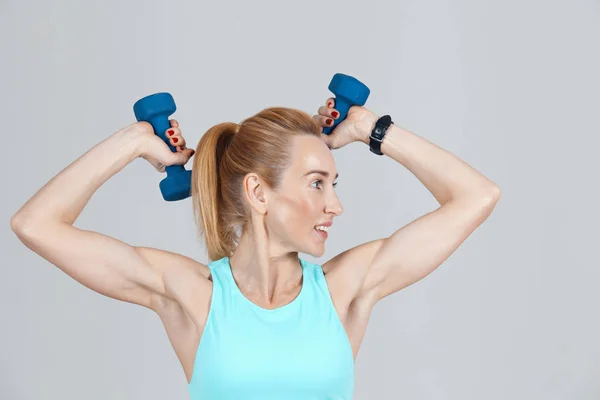 ダンベルを持つ手をトレーニング運動の中年の女性 — ストック写真