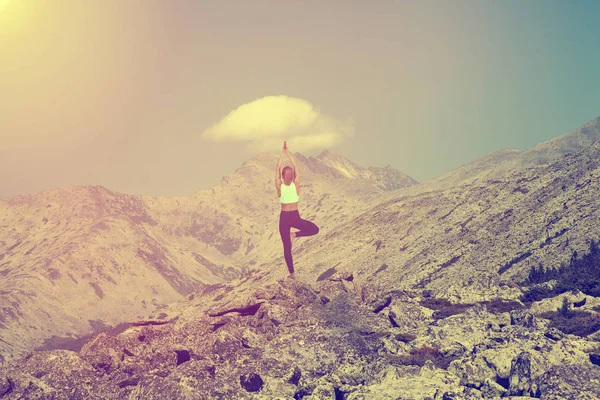 The yoga woman on the mountain at sunny day