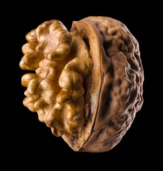 Siyah arka planda çekirdeği izole edilmiş yarı açık cevizli makro fotoğraf.