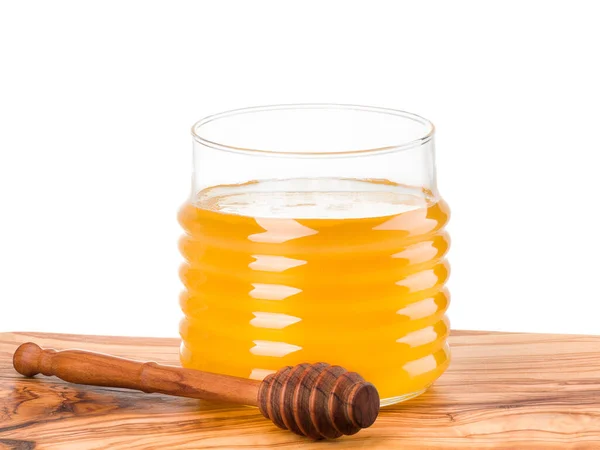 Tarro de vidrio lleno de miel y tarro de madera en tablón de madera aislado en blanco — Foto de Stock