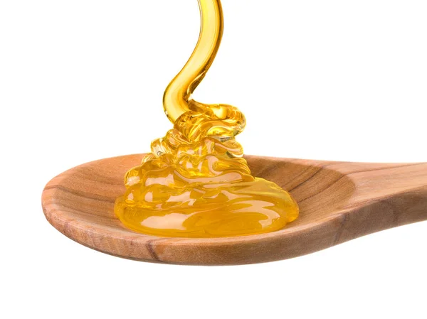 Caindo e fluindo mel em uma colher de madeira isolada em branco com caminho de recorte — Fotografia de Stock