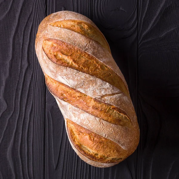 Bovenaanzicht foto van vers gebakken brood op zwarte houten tafel — Stockfoto