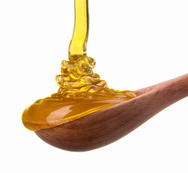 Tahta bir kaşığa düşen ve akan bal beyaz bir kaşık üzerinde kırpma yolu ile izole edilmiş.