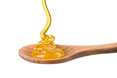 Tahta bir kaşığa düşen ve akan bal beyaz bir kaşık üzerinde kırpma yolu ile izole edilmiş.