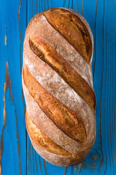 Vers gebakken roggebrood op een blauwe houten ondergrond — Stockfoto