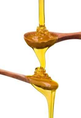 Tahta kaşık seti, beyaz üzerine dökülen ve akan bal.