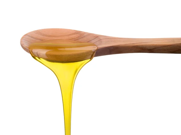 Caindo e fluindo mel em uma colher de madeira isolada em branco com caminho de recorte — Fotografia de Stock