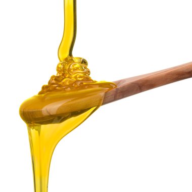 Tahta bir kaşığa düşen ve akan bal beyaz bir kaşık üzerinde kırpma yolu ile izole edilmiş.