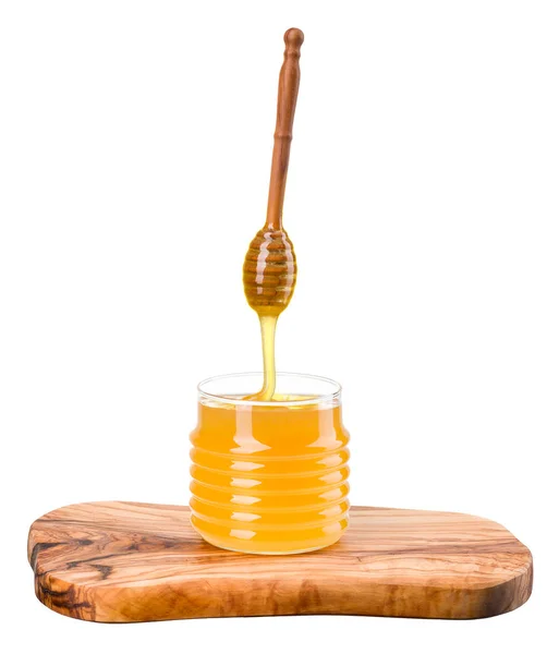 Frasco de vidro cheio de mel e mergulhador de madeira na prancha de madeira isolada no branco — Fotografia de Stock