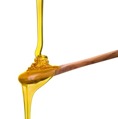 Tahta bir kaşığa düşen ve akan bal beyaz bir kaşık üzerinde kırpma yolu ile izole edilmiş.