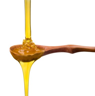 Tahta bir kaşığa düşen ve akan bal beyaz bir kaşık üzerinde kırpma yolu ile izole edilmiş.