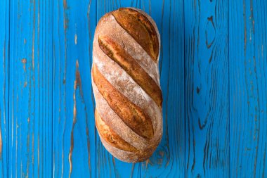 Mavi ahşap zemin üzerinde taze pişmiş çavdar ekmeği.