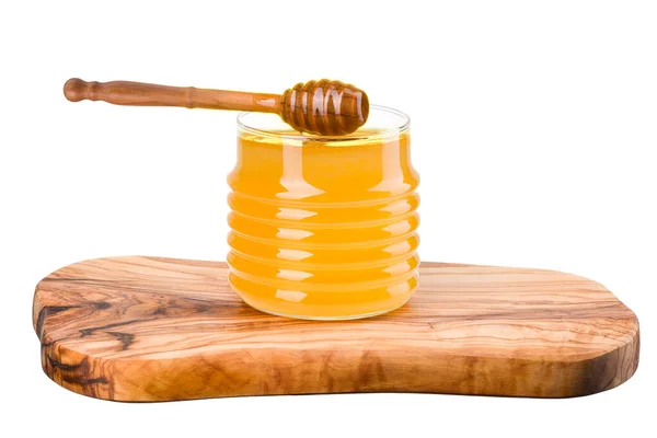 Glass jar full of honey and wooden dipper on wooden plank isolated on white — Stock Photo, Image