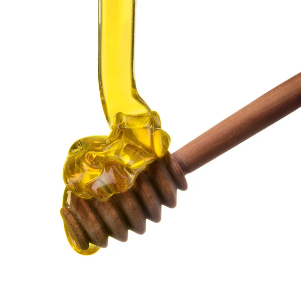 Падение и текущий мед на деревянную ложку, изолированную на белом с обрезкой пути — стоковое фото
