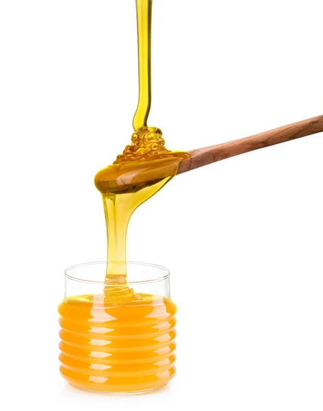 Frasco de vidro cheio de mel e colher de madeira isolada no fundo branco — Fotografia de Stock