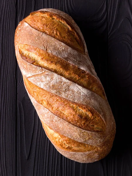 Bovenaanzicht foto van vers gebakken brood op zwarte houten tafel — Stockfoto