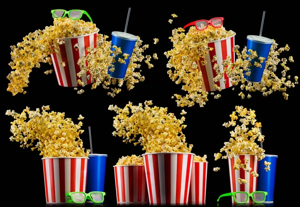 Set aus gestreiften Eimern mit Popcorn, Tassen mit Getränken und Gläsern isoliert auf schwarz — Stockfoto