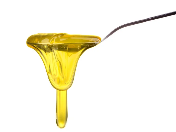 Miel que cae y fluye en una cuchara aislada en blanco con camino de recorte —  Fotos de Stock