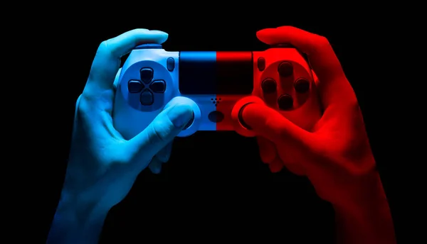 Хайман держит в руках белый геймпад для видеоигр в неоновом свете, изолированный на чёрном — стоковое фото