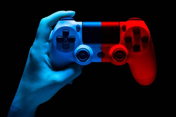 Hyman hand houden van witte video game gamepad in neon lichten geïsoleerd op een zwart — Stockfoto