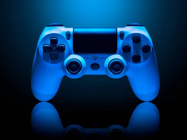 Белый джойстик видеоигры в синем неоновом свете, изолированный на черном — стоковое фото