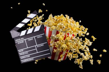 Uçan patlamış mısır ve film alkışları siyah zemin üzerinde izole edilmiş, televizyon veya sinema konsepti.