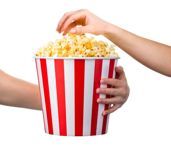 Kvinna hand tar popcorn från randig hink isolerad på vit bakgrund — Stockfoto