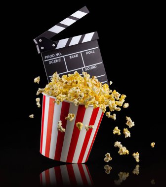 Uçan patlamış mısır ve film alkışları siyah arkaplanda izole edildi