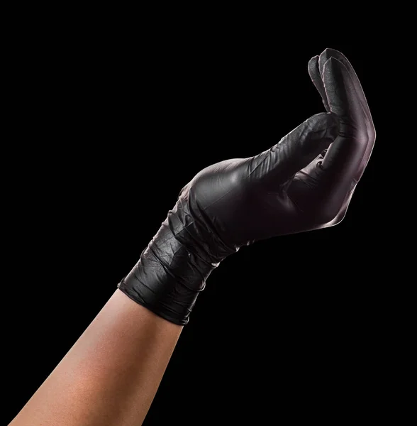 Hand Hand Mit Schwarzem Handschuh Der Etwas Auf Schwarzem Hintergrund — Stockfoto