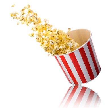 Beyaz arka planda izole edilmiş kağıt şeritli kovadan uçan patlamış mısır. Sinema kavramı ya da TV izlemek.