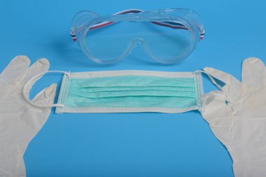 Ağız ve burnu kapatmak için tek kullanımlık hijyenik maske, şeffaf plastik laboratuvar gözlükleri, eldiven lateks el muayenesi, koruma konsepti covid-19
