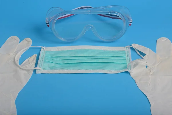 Ağız ve burnu kapatmak için tek kullanımlık hijyenik maske, şeffaf plastik laboratuvar gözlükleri, eldiven lateks el muayenesi, koruma konsepti covid-19