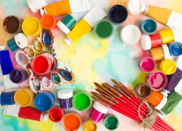 Paints, brushes and palette on the colorful background. — Stock Photo, Image