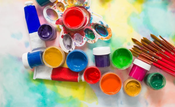 Tintas, pincéis e paleta sobre o fundo colorido . — Fotografia de Stock